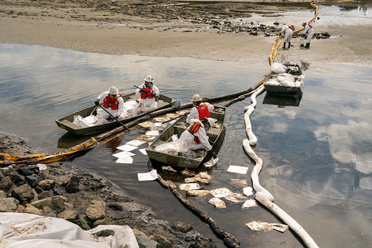 <i>Kyle Grillot for CNN</i><br/>Patriot Environmental employees work Monday to clear oil from the surface of the water inside Talbert Marsh