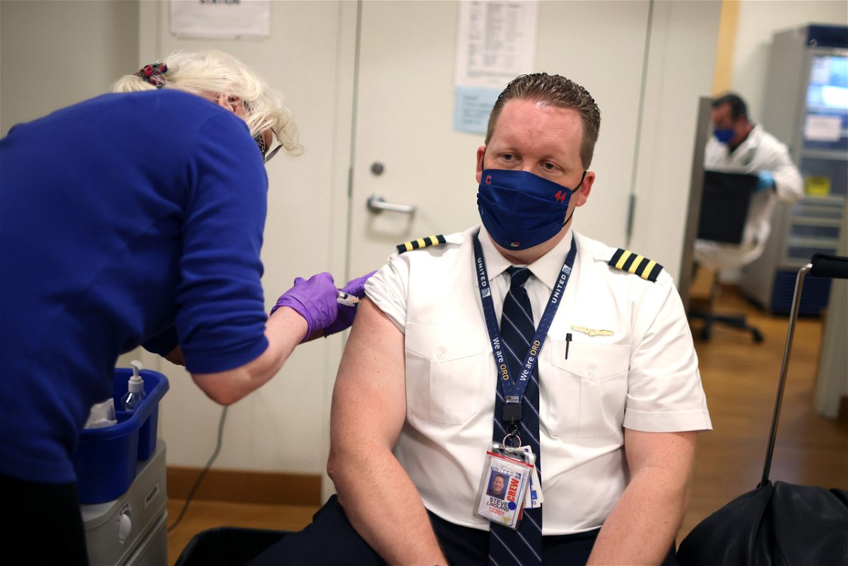 <i>Scott Olson/Getty Images</i><br/>United Airlines pilot Steve Lindland receives a Covid-19 vaccine at O'Hare International Airport in March 2021.