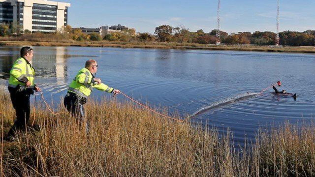 <i>State Police Association Of Massachusetts/ WBZ</i><br/>Massachusetts State Police troopers pull in a man who fell into the Neponset River in Dorchester on November 6 while trying to retrieve a drone.