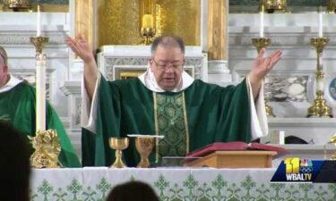 Father Bernard Carman worships during Mass. Father Carman was injured during an armed robbery in Baltimore.