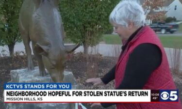 Carolyn Patterson points to an area that once contained a 70-pound bronze sculpture of a piglet. Thieves recently stole the sculpture.