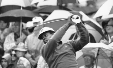 Lee Elder watches the flight of his ball as he tees off in the first round at the Masters in 1975.