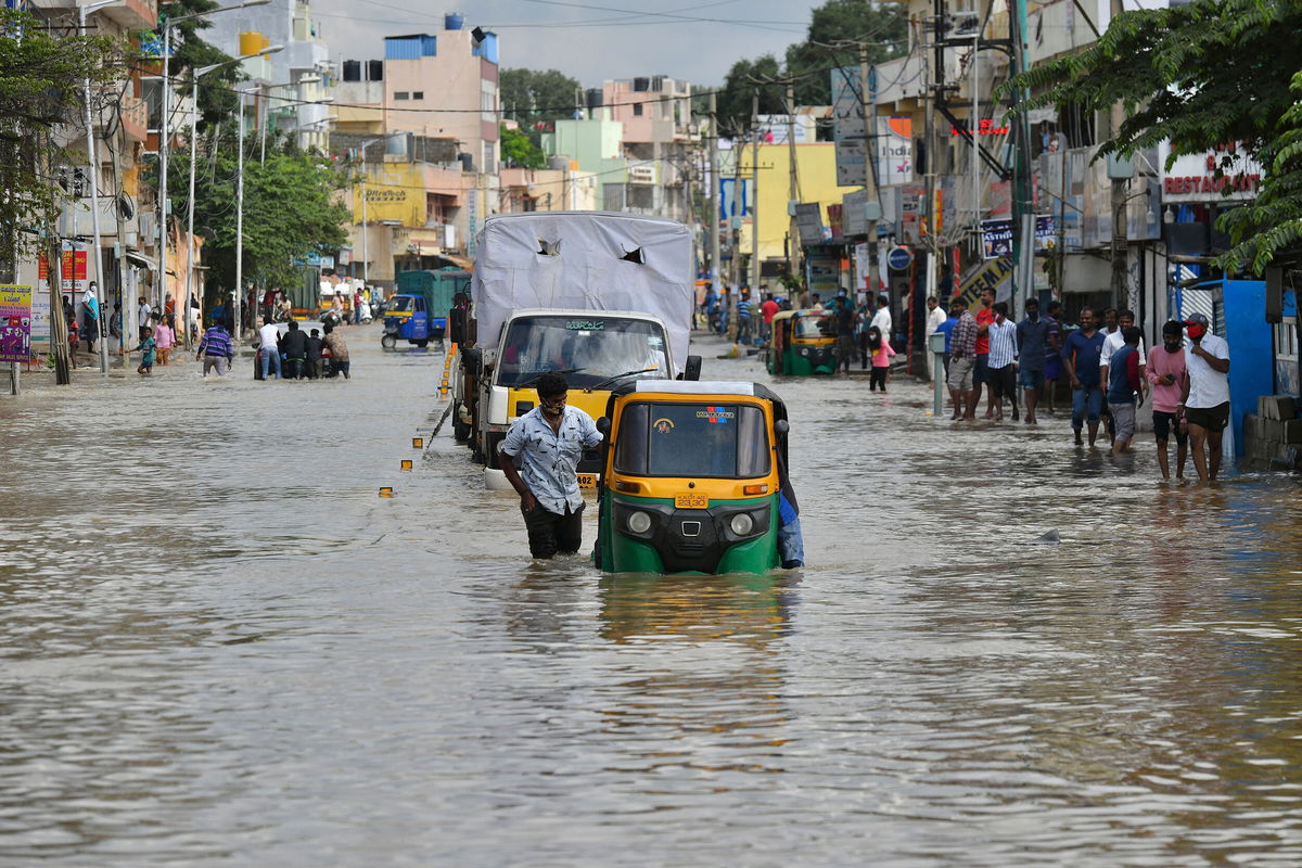 <i>Manjunath Kiran/AFP/Getty Images</i><br/>Commuters wade through a water-logged road following heavy rains in Bangalore on November 22