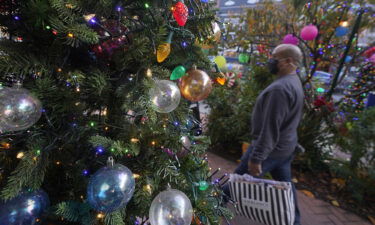 A pedestrian carries a bag past holiday decorations outside of Just for Fun & Scribbledoodles store during the coronavirus pandemic in San Francisco