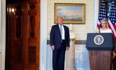 President Donald Trump listens as Cleta Mitchell speaks at a signing ceremony for a proclamation honoring the 100th Anniversary of the Ratification of the 19th Amendment in the Blue Room of the White House in Washington