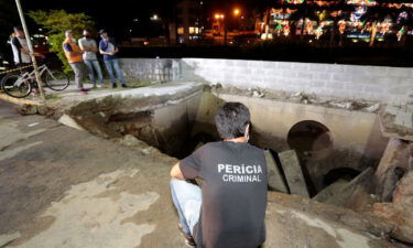 Officials survey the scene after a sidewalk collapsed in the city of Joinville on Monday.