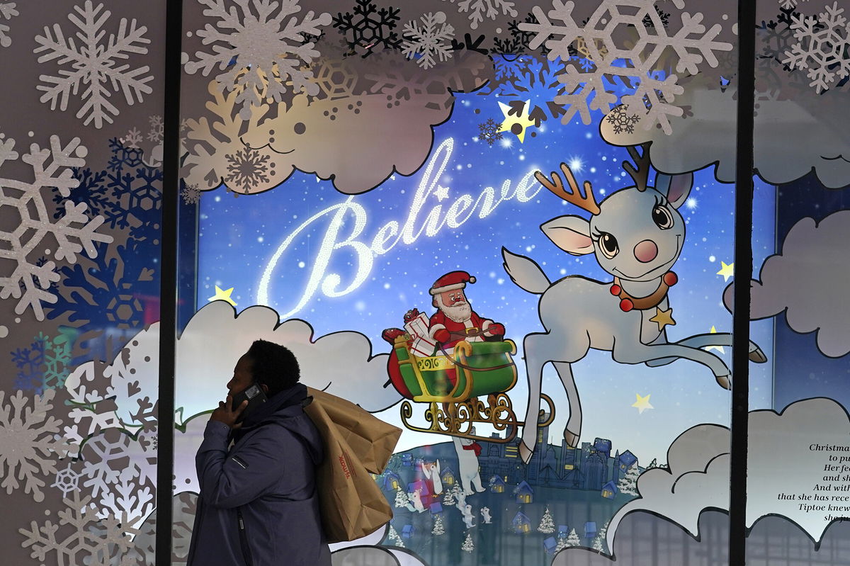 <i>Charles Krupa/AP</i><br/>A shopper carries bags over her shoulder while passing a holiday display window outside the Macy's store in the Downtown Crossing district