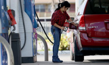 A customer pumps gas into her vehicle at a gas station on November 22