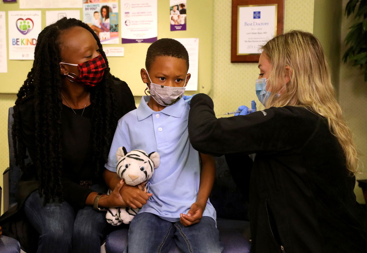 <i>Eric Seals/Detroit Free Press/USA Today Network</i><br/>The next step in vaccinating children is families finding the nearest dose. Tyann Davis holds her son Cameron Davis' hand as IHA Plymouth Pediatrics Medical Assistant Madison Peterson gives him the Pfizer Covid-19 vaccine.
