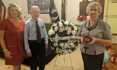 Marian Cook Haddock (left) holds her uncle's dog tag at the September ceremony with her daughter