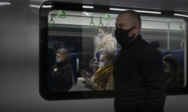 Commuters wearing face masks amid the ongoing Covid-19 pandemic ride on a metro train on October 25