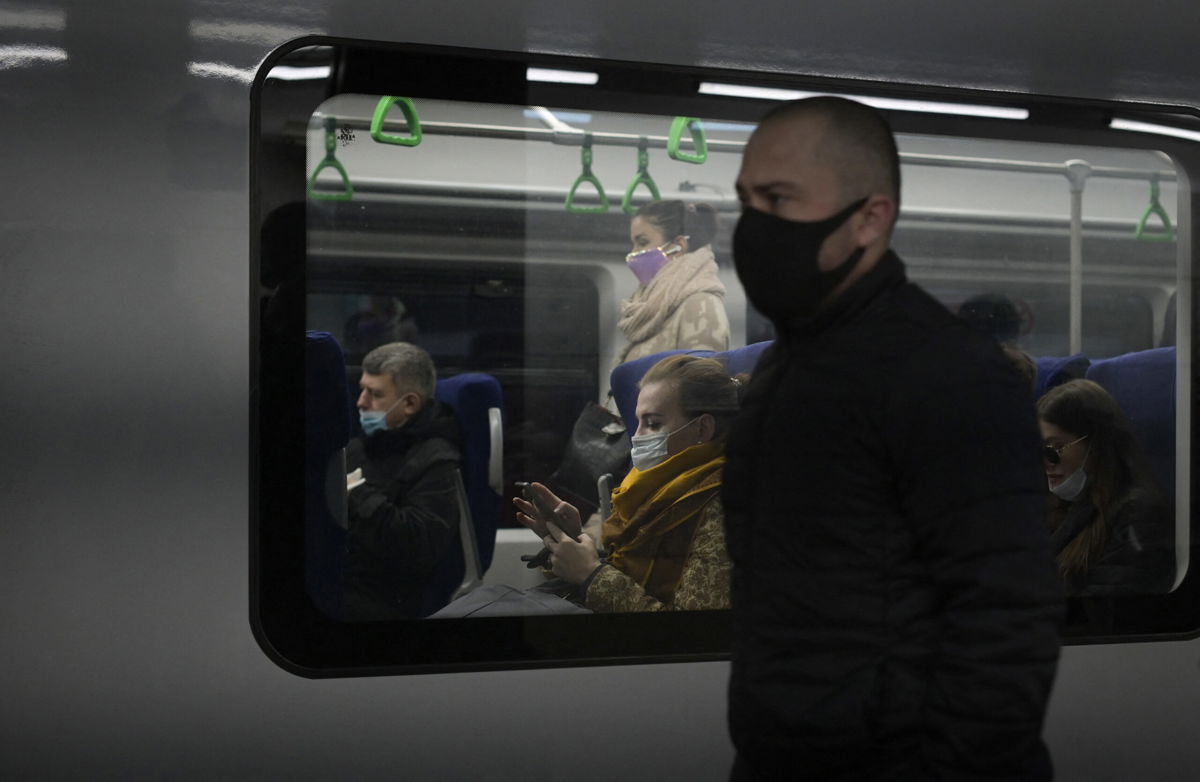 <i>NATALIA KOLESNIKOVA/AFP/GETTY IMAGES</i><br/>Commuters wearing face masks amid the ongoing Covid-19 pandemic ride on a metro train on October 25