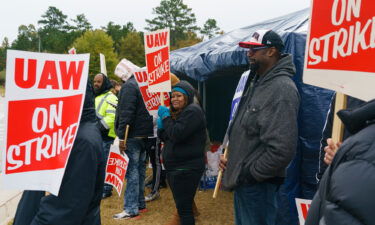 Workers hold signs during a strike outside the John Deere Regional Parts Distribution facility in McDonough