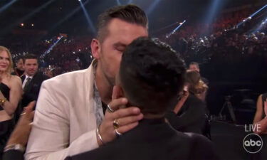 T.J. Osborne celebrates his 2021 CMA Awards win by kissing his boyfriend.
