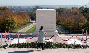 A woman arrives to place flowers during a centennial commemoration event at the Tomb of the Unknown Soldier