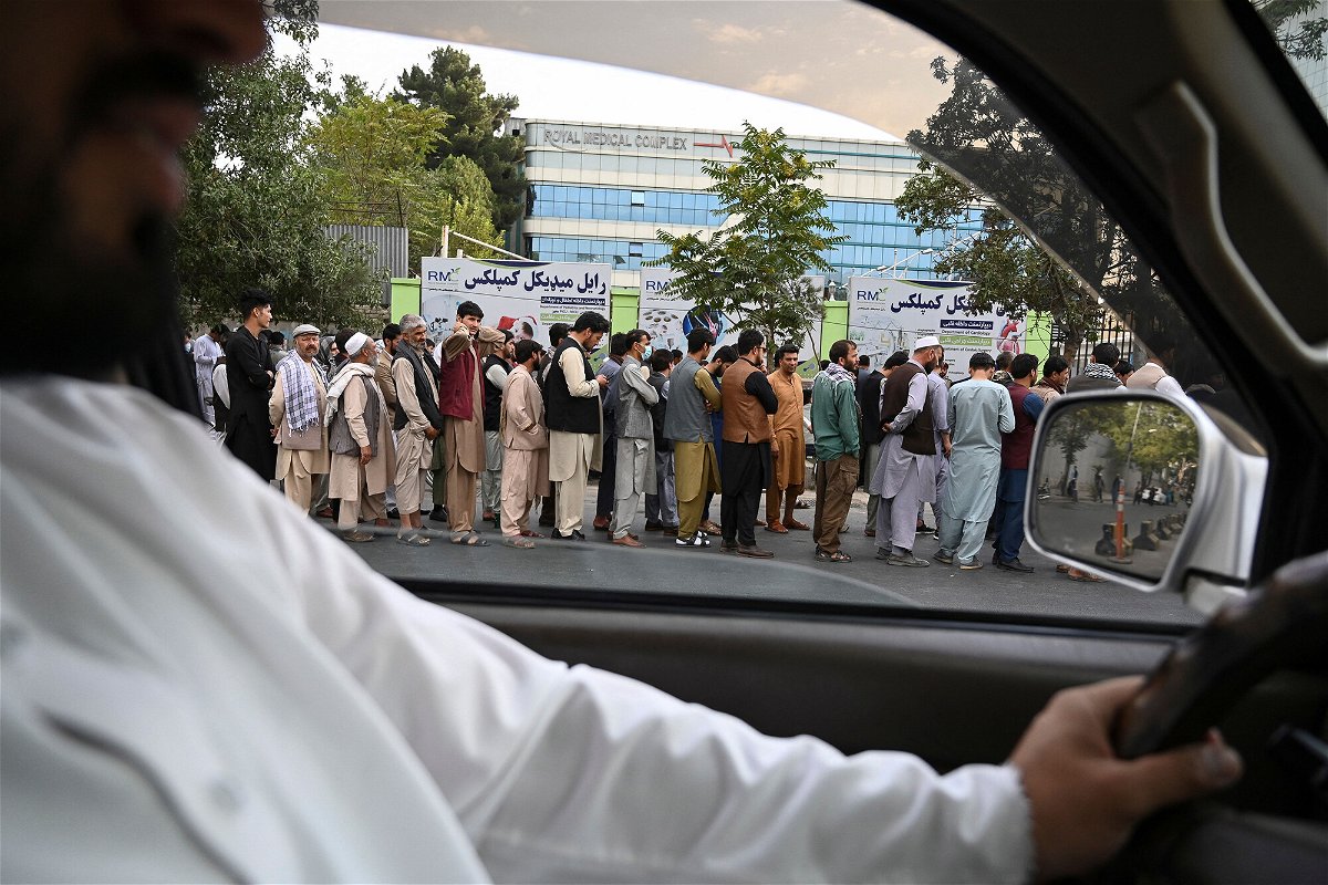 <i>Aamir Qureshi/AFP/Getty Images</i><br/>Afghans queue up as they wait for the banks to open and operate at a commercial area in Kabul on August 31.