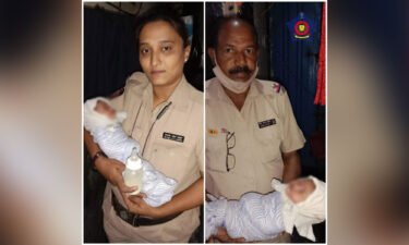 Mumbai Police hold a baby who was found in a drain.