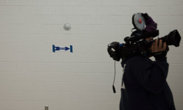 A  man carries a TV camera into a voting location in the Rocky Run Middle School on November 02