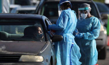 Healthcare workers conduct tests at a drive-thru COVID-19 testing site at the Dan Paul Plaza on December 29