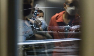 Mask mandates on planes may be good for business. Travelers wearing protective face masks are reflected in a window at Charlotte Douglas International Airport (CLT) in North Carolina