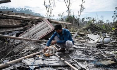 A man salvages some of his belongings from his damaged home in Lumajang on December 8.
