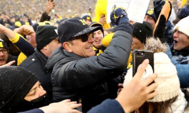 Michigan Wolverines Head Coach Jim Harbaugh celebrated with fans after defeating Ohio State.