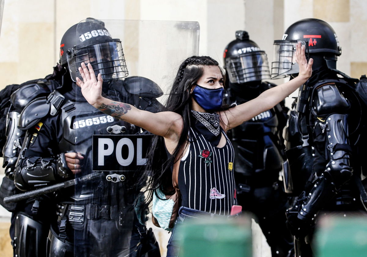<i>LEONARDO MUNOZ/AFP/AFP via Getty Images</i><br/>Riot police detain a demonstrator during protests against police brutality in Bogota on September 21
