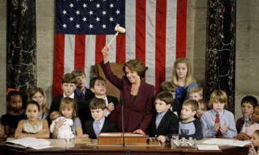 Pelosi waves the speaker's gavel while surrounded by her own grandchildren and the children of other members of Congress after being elected as the first woman speaker at a swearing in ceremony for the 110th Congress in January 2007.