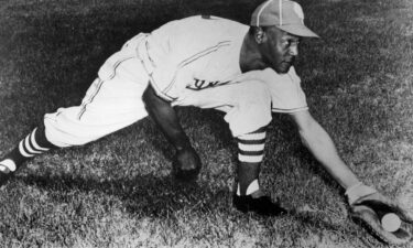 Buck O'Neil of the Kansas City Monarchs demonstrates his first baseman's stretch during a workout in the 1948 season. O'Neil is being considered for induction into the National Baseball Hall of Fame.