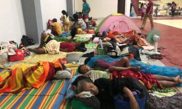 Residents sleep inside a sports complex turned into an evacuation center in Dapa town