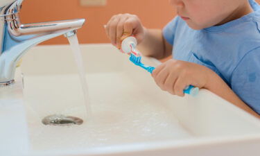 A child brushes his teeth in the bathroom.