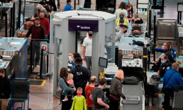 Christmas Eve air travel is well below 2019 levels amid flight cancellations as Omicron cases surge. Pictured are travelers at the Denver International Airport Friday