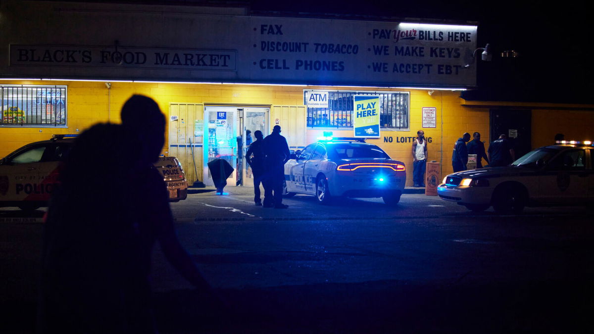 <i>Edmund D. Fountain for CNN</i><br/>Police respond to a shooting outside a food market in Jackson. The city recently raised starting pay for new police officers to  $30