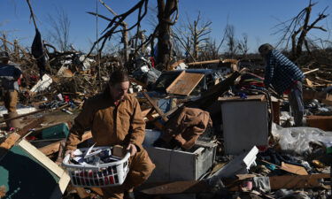 People gather belongings from a tornado damaged home after extreme weather hit the region December 12