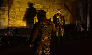 Paramilitary troopers stand guard at the site of an attack on the outskirts of Srinagar on December 13.