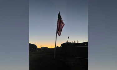 An American flag is seen in the rubble of Marsha Hall's home. It is one of 25 flags that used to fly in the front yard year-round.