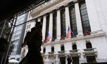 People walk by the New York Stock Exchange on December 13 in New York City.