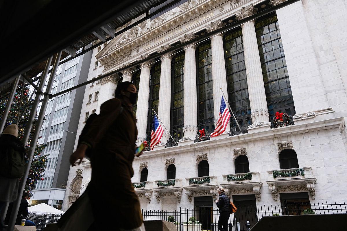 <i>Spencer Platt/Getty Images</i><br/>People walk by the New York Stock Exchange on December 13 in New York City.