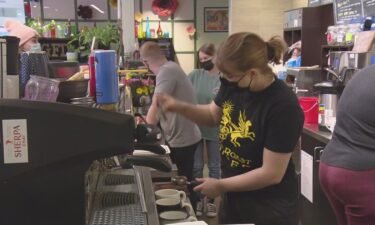 Workers make coffee at the Grounds for Dismissal coffee shop in Denver