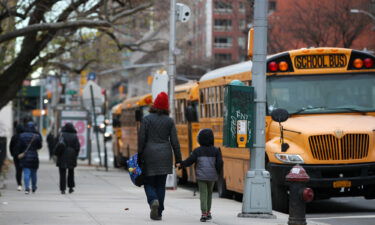 A parent walks with their child outside a New York City elementary school on December 7