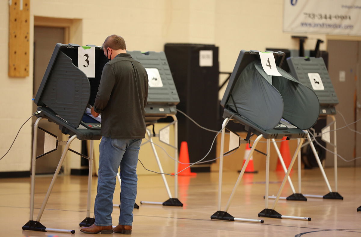 <i>Sharon Steinmann/Bloomberg/Getty Images</i><br/>A voter wearing a protective mask casts a ballot at a polling location for the 2020 Presidential election in Houston