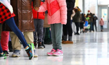 Omicron is the latest disaster for working parents. Cambridge students are seen here waiting in line at King Open Elementary School with their parents to be tested for the COVID-19 virus.