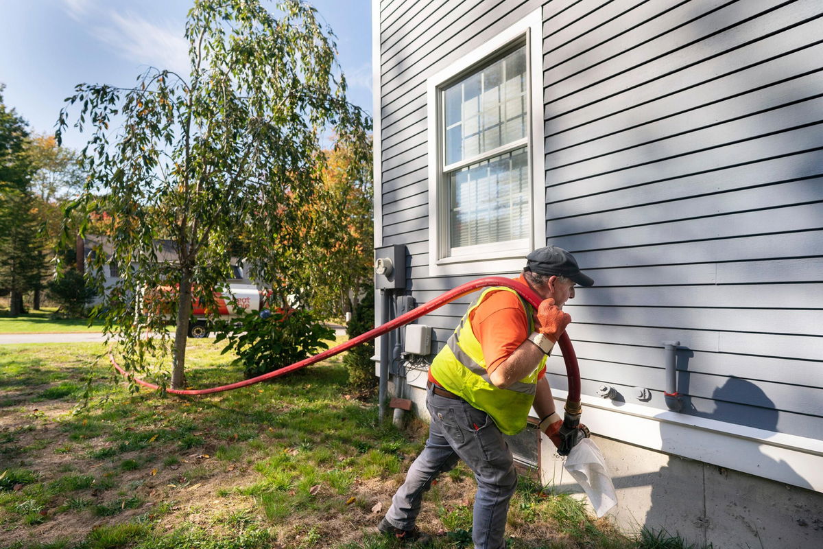 <i>Gregory Rec/Portland Press Herald/Getty Images</i><br/>A man delivers oil to a home in Scarborough on Wednesday