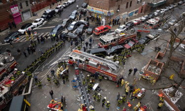 Firefighters work outside an apartment building after a fire in the Bronx