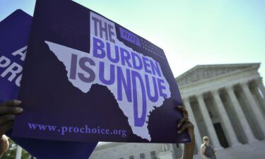 An abortion rights activist holds placards outside of the US Supreme Court before the Court struck down a Texas law placing restrictions on abortion clinics in 2016 in Washington