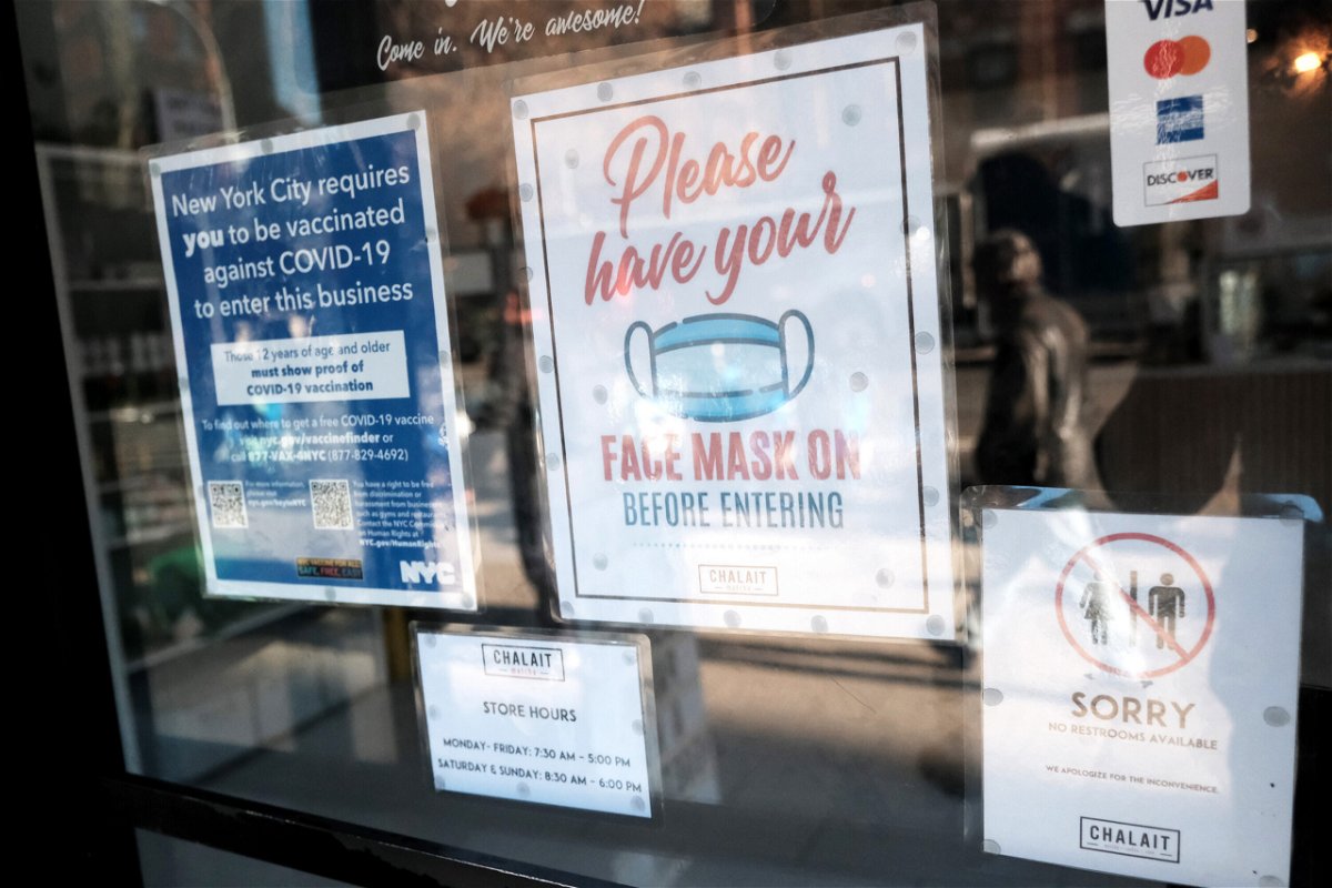 <i>Spencer Platt/Getty Images</i><br/>A sign on the door of a coffee shop in Manhattan asks for proof of vaccination and the wearing of a mask on December 13