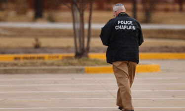 A police chaplain walks near the Congregation Beth Israel synagogue in Colleyville