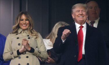 Former first lady and president of the United States Melania and Donald Trump look on prior to Game Four of the World Series on October 30