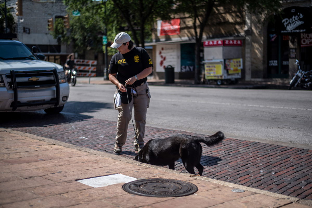 <i>Sergio Flores/Getty Images</i><br/>An officer surveys the scene of a shooting on June 12