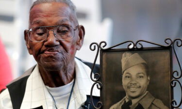 World War II veteran Lawrence Brooks holds a photo of him taken in 1943